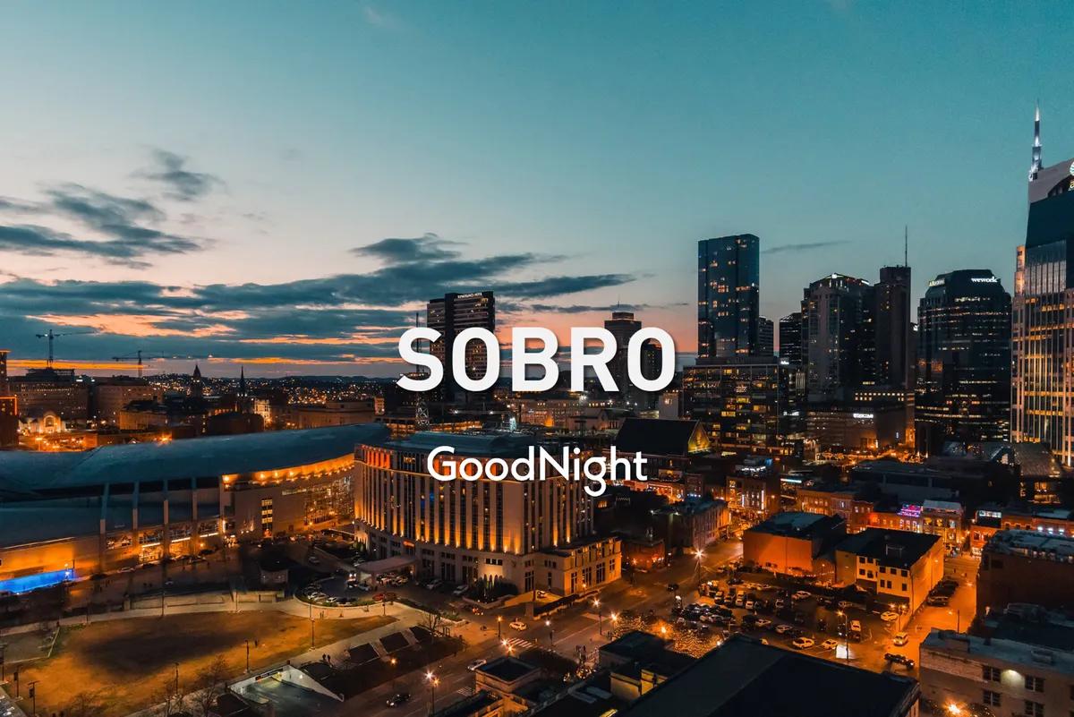 A sweeping city skyline viewed at sunset, with the city lights starting to twinkle. The scene combines a sense of energy with serenity, suggesting both the convenience of urban amenities and the calming views available nearby.